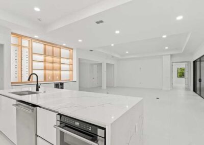Modern kitchen island overlooking open concept living space in a custom Vero Beach home.