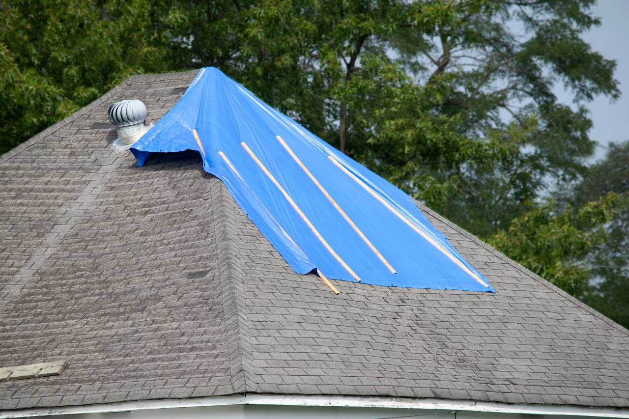 Blue tarp covering storm-damaged roof in Sebastian Florida as temporary protection