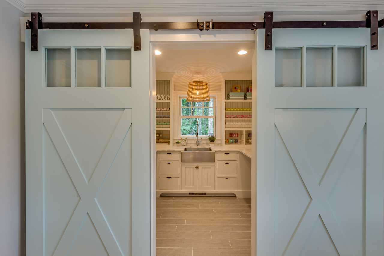 Laundry room remodel with farmhouse barn doors and custom cabinetry