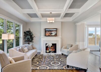 Living room remodel featuring fireplace, tray ceiling, and custom coffered design.