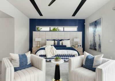 Contemporary bedroom remodel with navy accent wall, upholstered headboard, and modern décor.