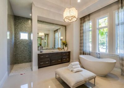 Luxury spa-inspired bathroom remodel with chandelier, freestanding tub, and double vanity in Vero Beach