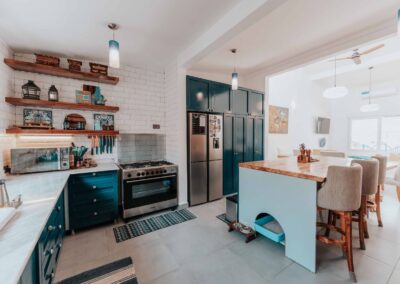 Modern kitchen remodel with blue cabinets, wood island, and stainless steel appliances.